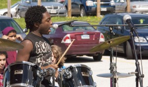Noah Pierre vocalizing and banging on drums at the Spring Lunch Jam.