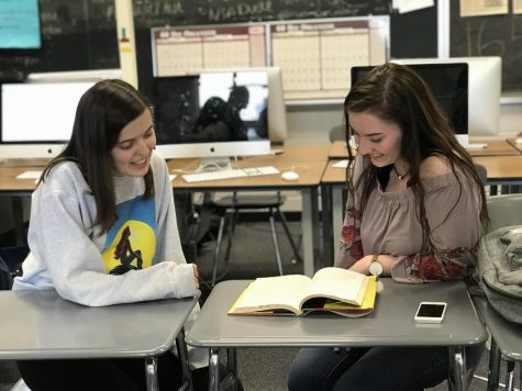 Jane Hilger and Savannah Jackson discuss a book during some free time. 