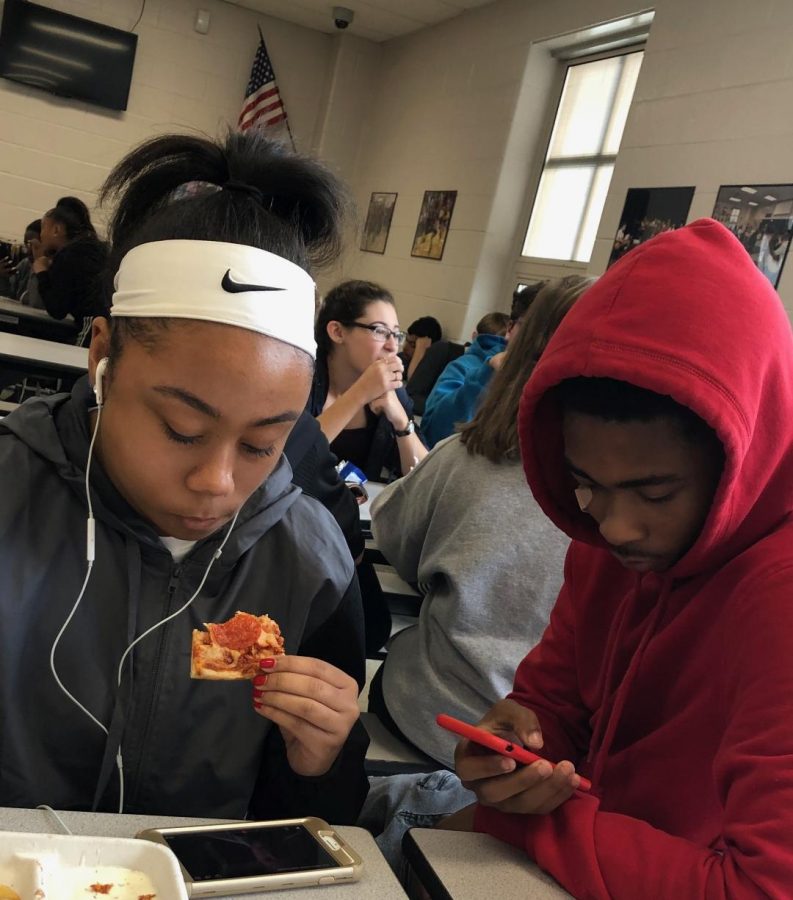 Macayla+Miles+%28junior%29+and+Corey+Cooke+%28senior%29+enjoy+their+free+lunch+period+preoccupied+with+their+cellphones.+