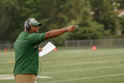 Coach Henderson on the sideline intensely instructing his team 