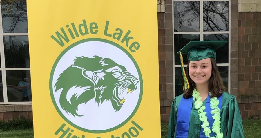 Laura Krell, Wilde Lake senior, takes a picture in her cap and gown at school. 