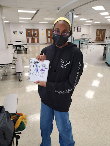 Senior Deyonna McGeachy-Alexander with one of her drawings. While it is colored, she started by sketching it during class. (Photo by Cameron Franks)