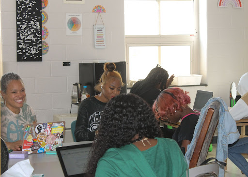 Ms. Wright (left) and students share their baby pictures and chat in the Peace Room during lunch time.