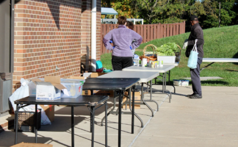 On Saturday at 8:30 AM, thirty minutes before customers can come, Ms. Kirk (left) and a volunteer, Mr. Jacques Moutome (right), plan how they will organize the tables. 