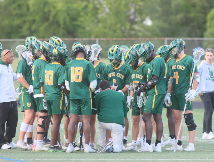 On+April+26%2C+2023%2C+the+Cats+and+their+coaches+%28Coach+Bell%2C+left%29+hudle+during+their+%0Agame+against+Marriotts+Ridge.+Junior+Lewis+Collora+says+that+the+new+coaching+staff+%0Ahas+lead+to+the+team%E2%80%99s+overall+improvement.+%E2%80%9COur+coaching+has+improved.+We+have+a+%0Alot+of+new%2C+good%2C+strong+coaches%2C%E2%80%9D+he+said.