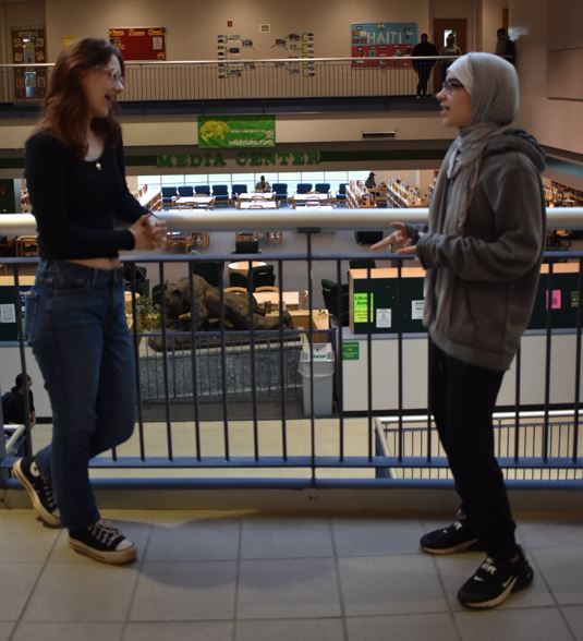COLUMBIA, MARYLAND, MARCH 
19, 2024 -- Speech and Debate captains  Aly Abel and Yasmin Roach discuss their debate season in the hallway Aly has  been on the team for four years and both  have earned multiple medals and awards  at Speech and Debate competitions.