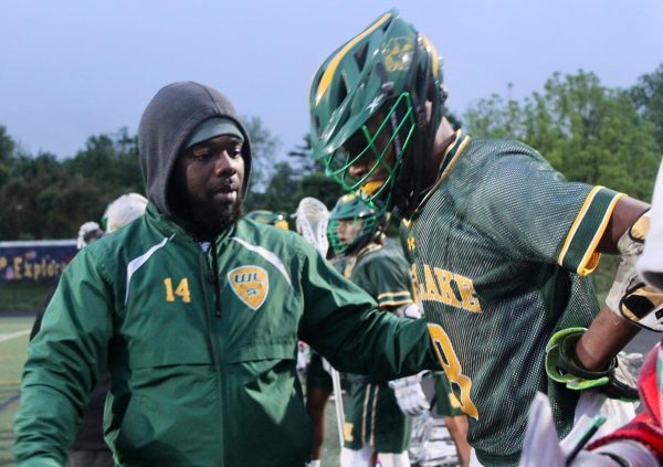 GAITHERSBURG, MD, MAY 10, 2024 - Coach Saquan Maxwell gives midfielder Riyadh Assani words of encouragement as he comes off of the field during the Boys Varsity Lacrosse regional semifinals.
