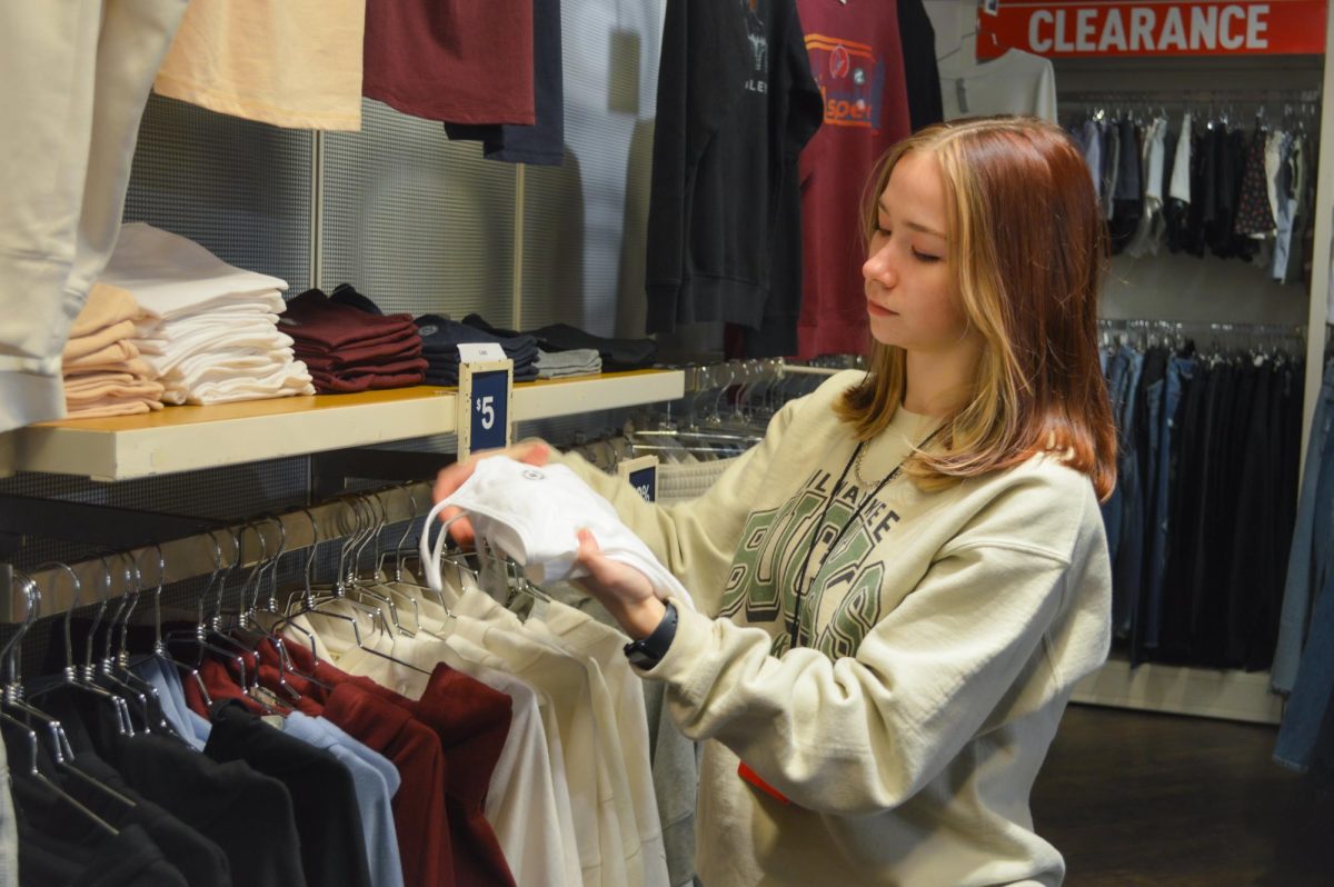 COLUMBIA, MARYLAND, JANUARY 4, 2025 - Senior Siena Mullican restocks and reorganizes 
shelves at her retail job, Aeropostale, in the Mall of Columbia.