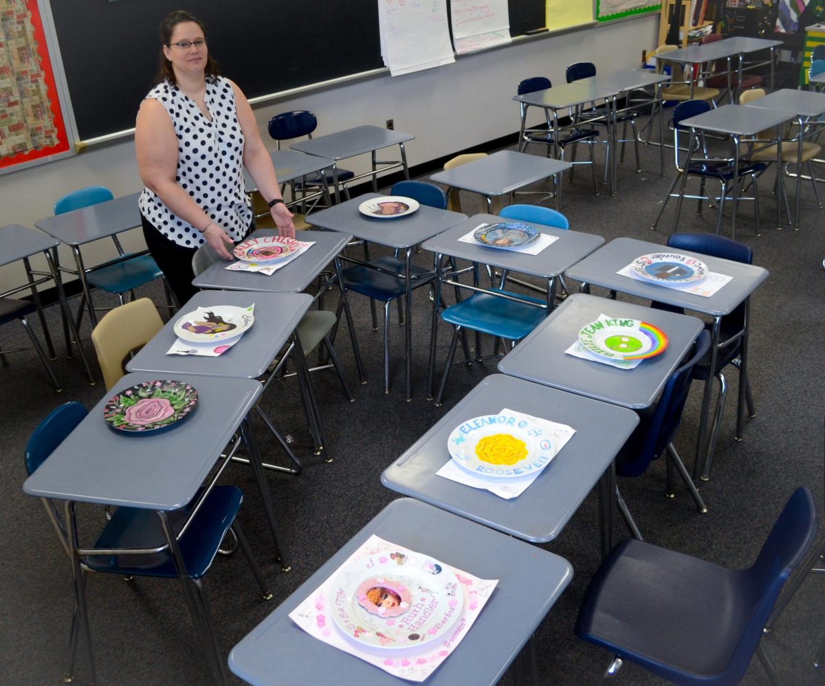 COLUMBIA, MARYLAND, FEBRUARY 4, 2025 - Women’s Studies teacher Ms. Volpe sets the table with glass plates made by her students that highlight women contributions throughout history.